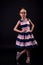 Stylish schoolgirl in a lush dress posing on a black background