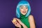 Stylish sensual girl in blue wig posing with macaron isolated