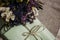 Stylish simple wrapped gift and rustic bouquet, on wooden backg