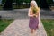 Stylish slender smiling girl with blond long hair holds a bouquet of wild flowers in her hands