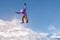 Stylish snowboarder with helmet and mask jumps from high snow slope