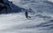 Stylish snowboarder walks with his beautiful snowboard through windstorm. Strong gale raging on the top of mountain and man in