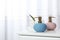 Stylish soap dispensers and lily on table against blurred background