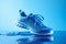 Stylish sport shoes on blue background with water, simple urban aesthetics. Sportswear, minimalist style and fashion, running