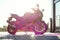 Stylish sports motorcycle with purple foam on the self-service car wash at sunrise.