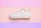 Stylish sporty sneaker on color background, top view
