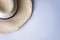 Stylish straw hat on wall with diagonal linear pattern
