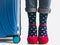 Stylish suitcase, women`s legs, bright socks and pink shoes