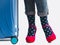 Stylish suitcase, women`s legs, bright socks and pink shoes