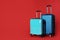 Stylish suitcases on color background.