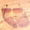 Stylish sunglasses lie on a sandy beach, transparent glass, light and shadow