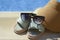 Stylish sunglasses, visor cap and slippers at poolside on sunny day. Beach accessories