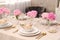 Stylish table setting with beautiful peonies and fabric napkins indoors