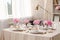 Stylish table setting with beautiful peonies and fabric napkins indoors