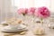 Stylish table setting with beautiful peonies and fabric napkins indoors