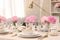 Stylish table setting with beautiful peonies and fabric napkins indoors