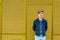 Stylish teen boy over industrial yellow background copyspace