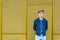 Stylish teen boy over industrial yellow background thinking