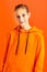 Stylish teenage girl in orange hoodie. Photo session in the studio