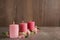 Stylish tender composition with burning candles and flowers on table against wooden background, space for text