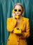 Stylish ukrainian woman in yellow sunglasses and jacket with deal phone