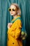 Stylish ukrainian woman in yellow sunglasses and jacket with lemons in net bag