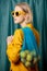 Stylish ukrainian woman in yellow sunglasses and jacket with lemons in net bag
