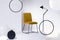 Stylish velvet yellow chair next to tall industrial black lamp in white interior