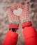 Stylish watch on woman hand, with snow heart in hands