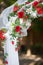 Stylish wedding arch with red roses and white lilies, garden