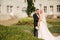 Stylish wedding couple in the park by the castle. Gorgeous bride with her handsome husband