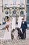 Stylish wedding couple with two purebred dogs in ancient european city center