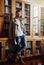 He stylish and well read. Portrait of a handsome and stylish young man leaning against a bookcase at home.