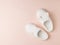 Stylish white house slippers on a light pastel background. Top view. Flat lay