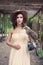 Stylish woman with bird outdoors. Perfect girl in fashionable dress and fedora hat