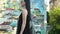 Stylish woman in black dress and sunglasses walk in slow motion against graffiti