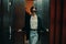 Stylish woman in black jacket and sunglasses posing in elevator, fashion model, dark cinematic light and color, glamor