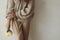 Stylish woman in cozy knitted sweater posing with chrysanthemum in hand close up on background of rustic wall. Moody fall, cozy