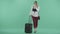 A stylish woman drinks coffee standing near luggage