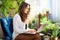 Stylish woman at modern home in sunny day using laptop