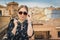 Stylish woman posing in the old part of the town against tile roofs. Medieval city of Toledo in the center of Spain.