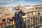 Stylish woman posing in the old part of the town against tile roofs. Medieval city of Toledo in the center of Spain.