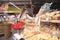 Stylish woman with a red basket for products in her hands chooses bread in a supermarket