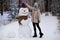 Stylish woman sculpt a big real snowman