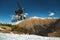 Stylish woman snowboarder makes a trick in flight. Snowboard jump from a kicker against the backdrop of mountains