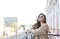 Stylish woman standing on balcony in city