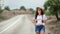 Stylish woman in straw hat and trendy sunglasses walking on highway. Shot with RED camera in 4K