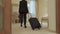 Stylish woman with suitcase just arrived in a hotel room