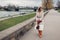 Stylish woman tourist walking along pier by Wisla river in Krakow, Poland enjoying landscape. Europe spring trip