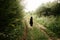 stylish woman traveler walking in sun light in woods with photo